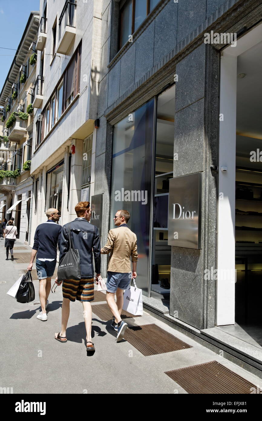 Three men passing a fashion boutique, Via Montenapoleone, Golden Triangle, Milan, Lombardy, Italy Stock Photo