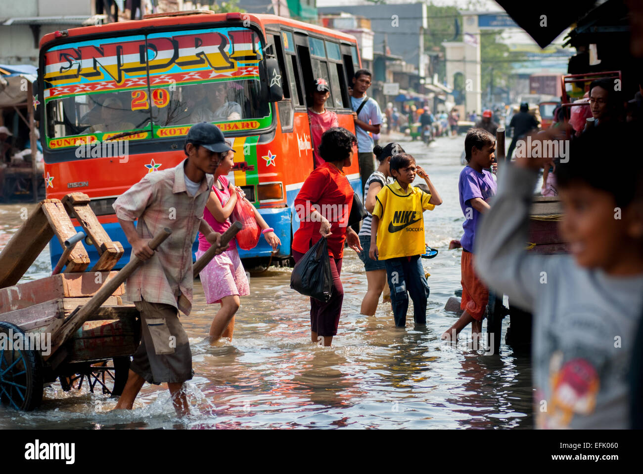 Northern Jakarta city residents passing through sea tides in Muara Baru, North Jakarta. Stock Photo