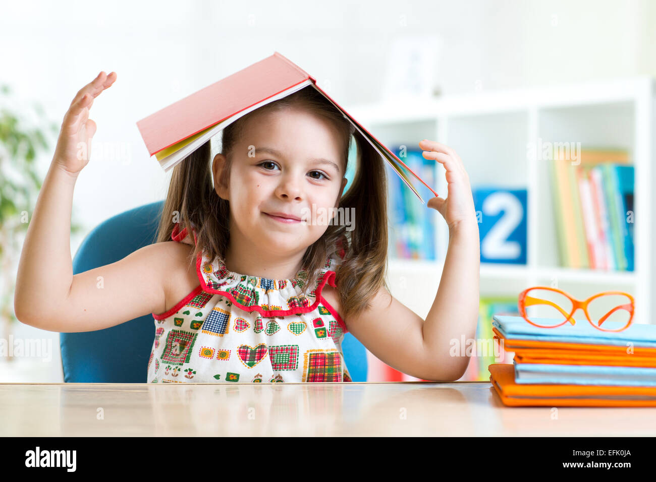 preschooler kid girl with book over her head Stock Photo Alamy