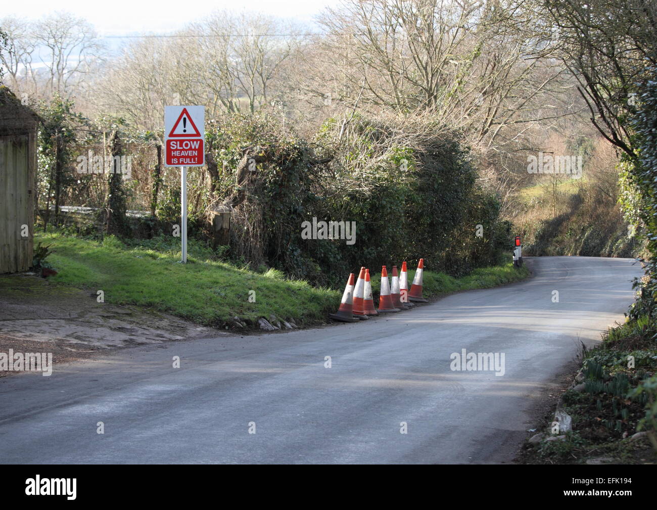 A funny road sign in Devon, England that is trying to make drivers slow down in the narrow country lane. Stock Photo