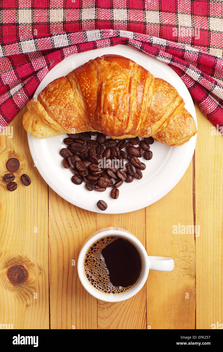 Cup of hot coffee with croissant on wooden table. Top view Stock Photo ...