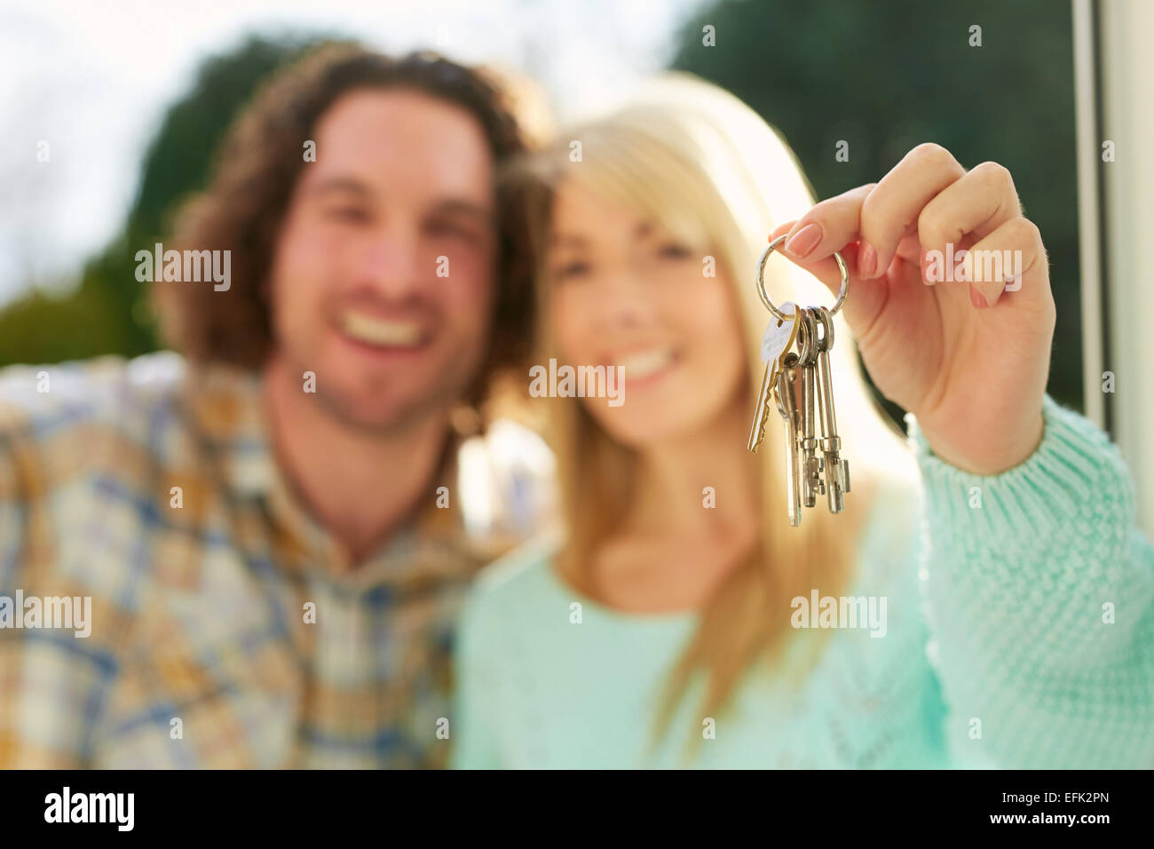 First time buyers holding keys to new house Stock Photo