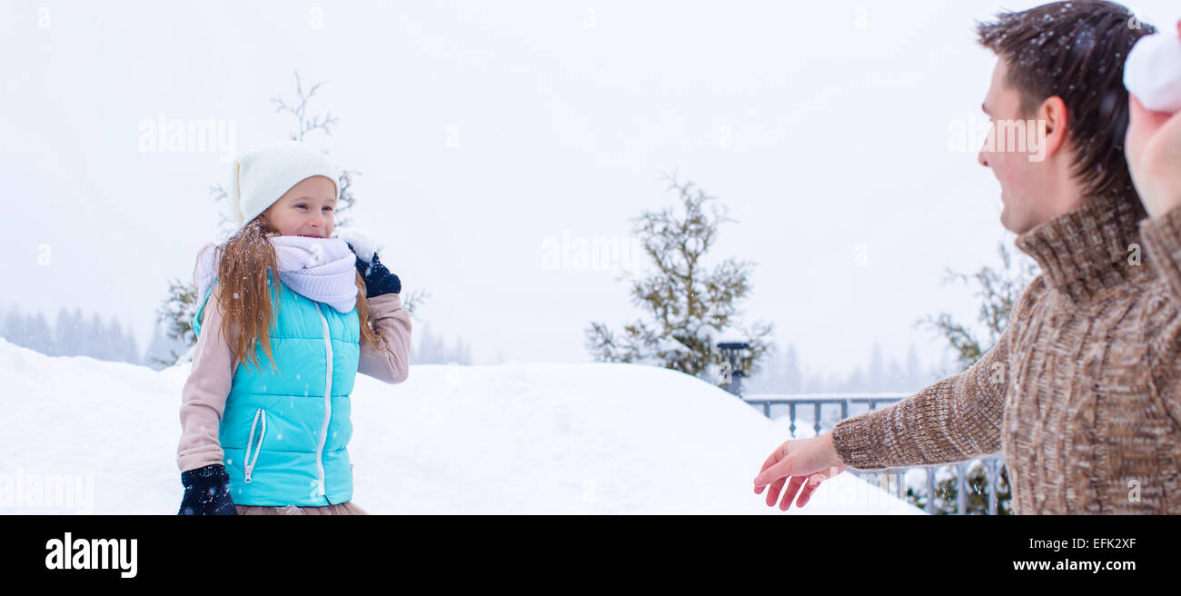 Happy father and little girl playing snowballs in winter snowy day ...
