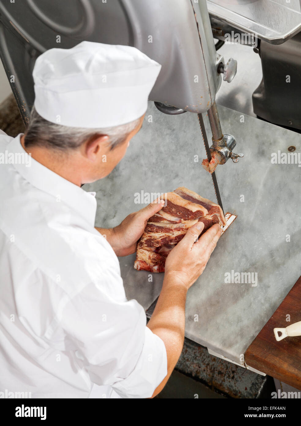 Butcher Cutting Fresh Meat With Bandsaw Stock Photo Alamy