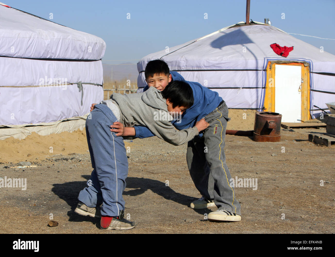 Children practice wrestling in front of the traditional Mongolian tents (ger), Mongolia Stock Photo
