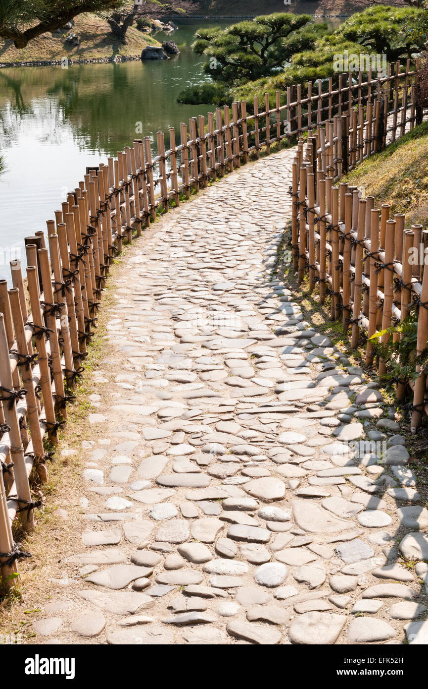 Ritsurin-koen garden, Takamatsu, Japan. A traditional path made from cobblestones and lined with low bamboo fences Stock Photo