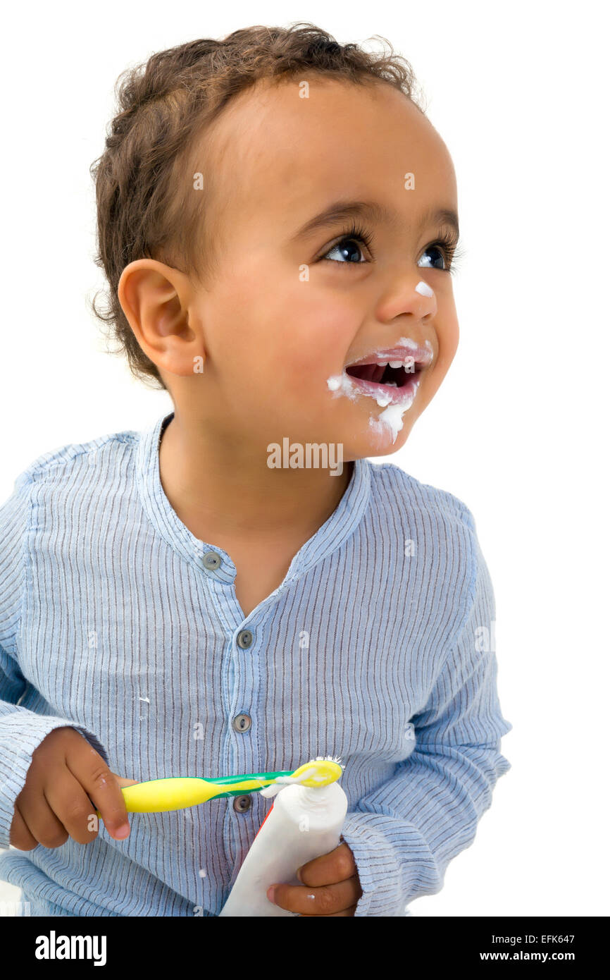 Smiling 18th month old African toddler boy brushing his teeth Stock