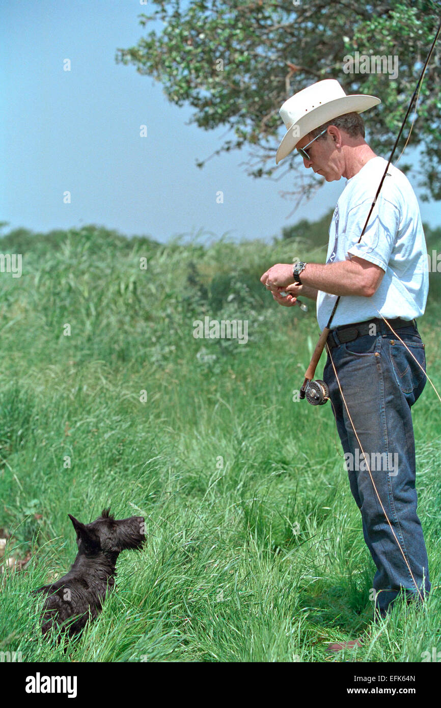 US President George W. Bush wearing a cowboy hat with his dog Barney as he goes fishing at the Ranch April 28, 2002 in Crawford, Texas. Stock Photo