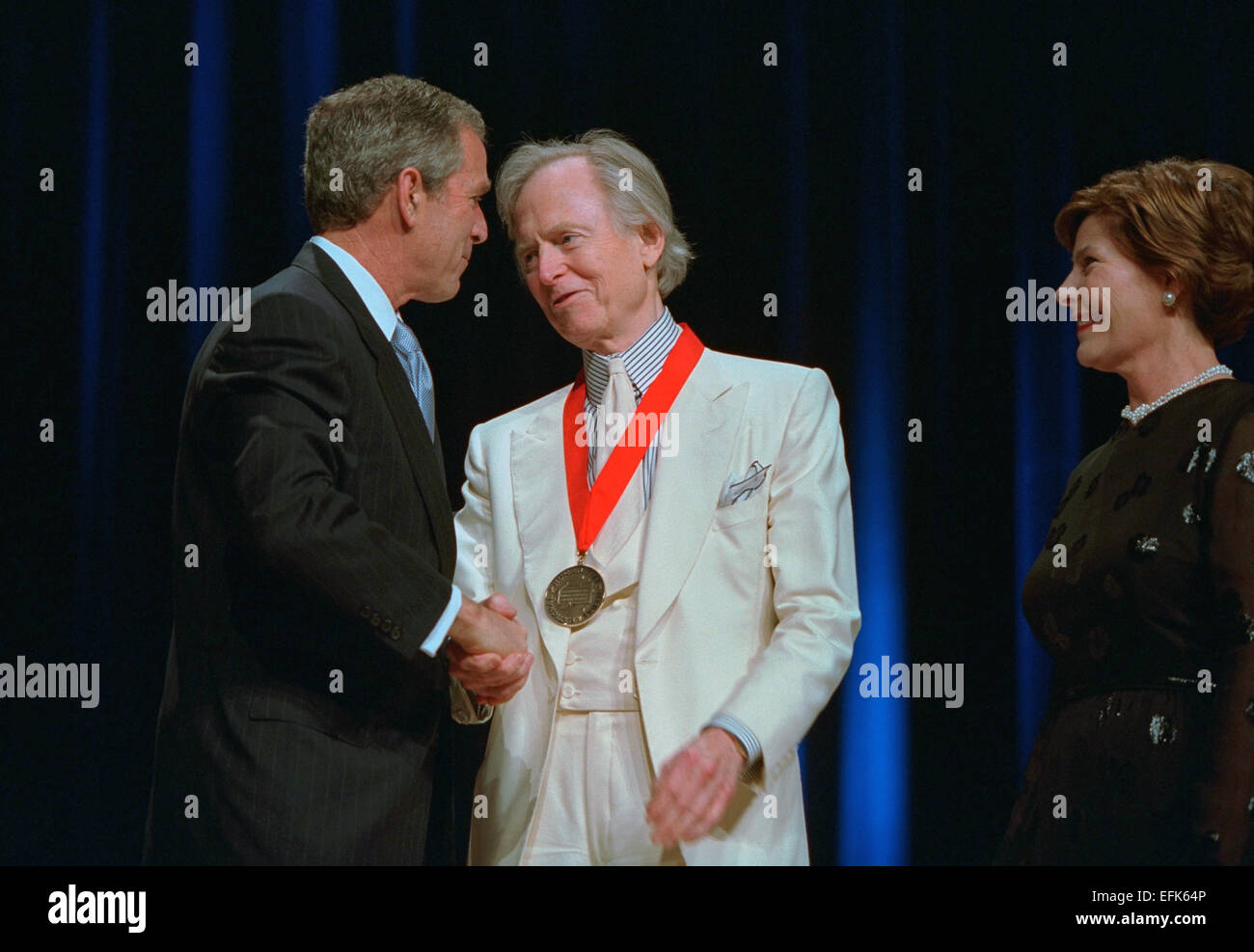 US President George W. Bush and First Lady Laura Bush present the 2001 National Medal of Arts and National Humanities Awards to author Tom Wolfe at the DAR Constitution Hall April 22, 2002 in Washington, DC. Stock Photo