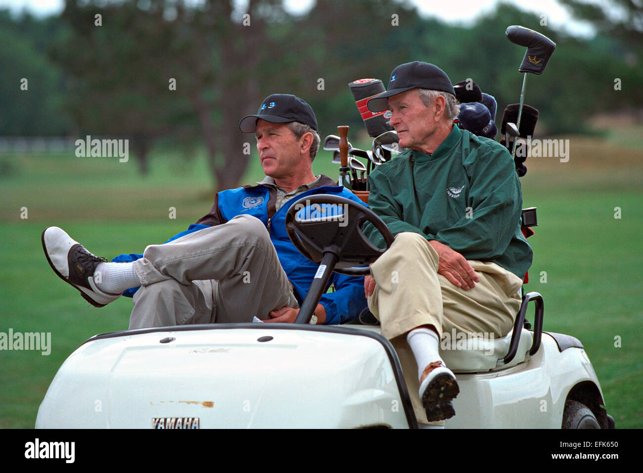 US President George W. Bush sits in a golf cart with his father former President George H.W. Bush during a round at Cape Arundel Golf Club July 6, 2001 in Kennebunkport, Maine. Stock Photo