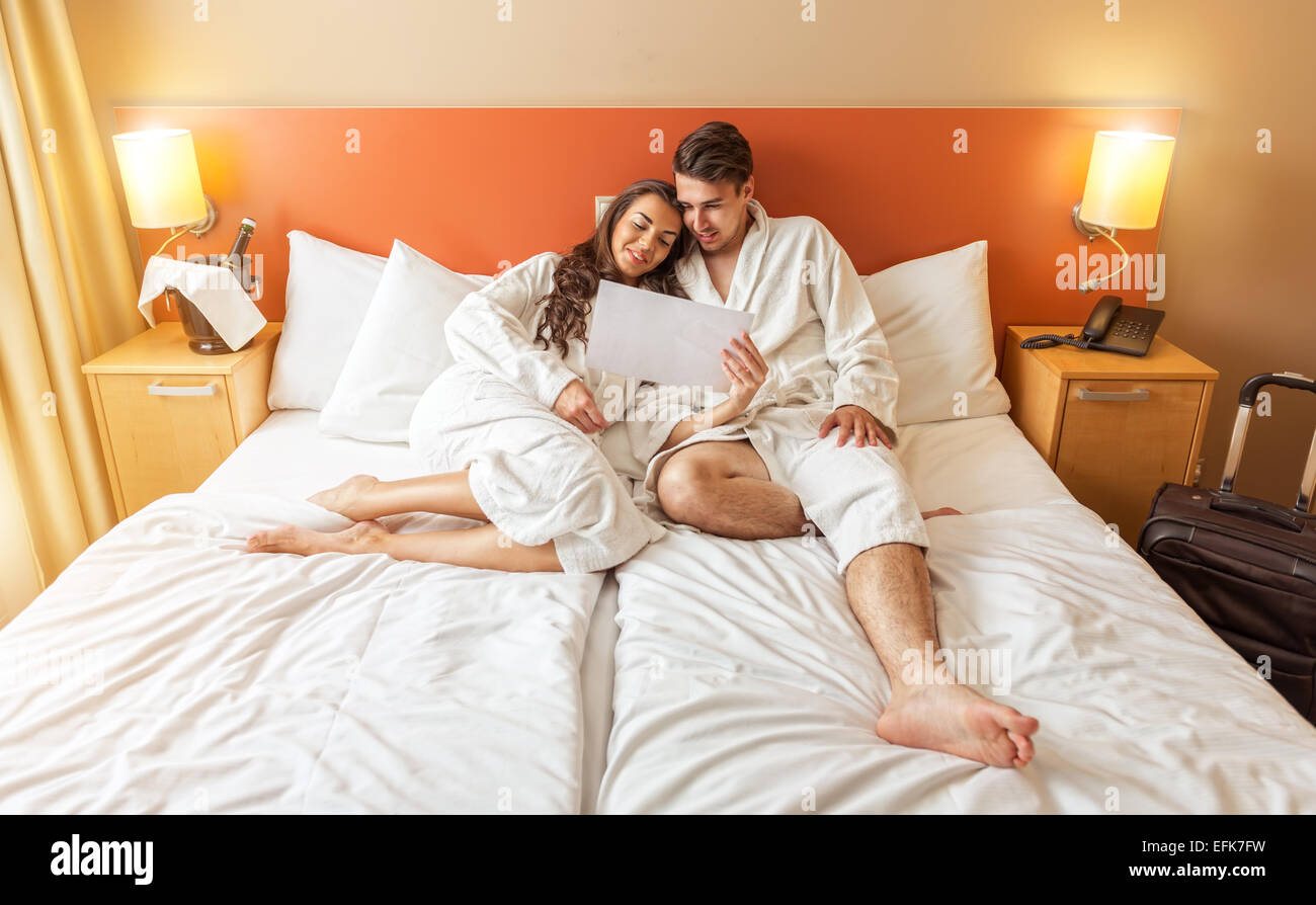 Young Couple lying in the bed of a hotel room Stock Photo