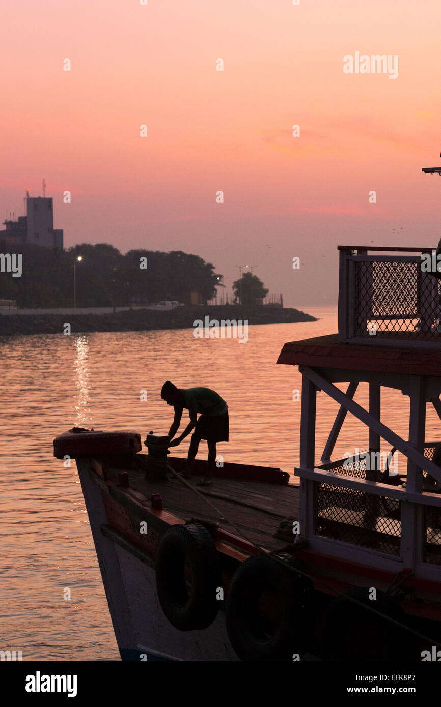 India, Maharashtra, Mumbai, Colaba district,  man silhouetted on boat in Mumbai harbour near Gateway of India Stock Photo