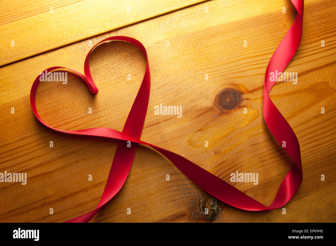 Red ribbon made from silk over a wooden background Stock Photo - Alamy