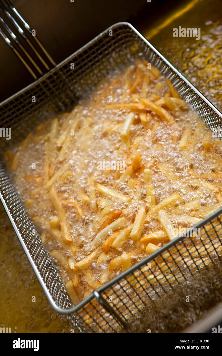 French fries cooking in a deep fryer Stock Photo Alamy