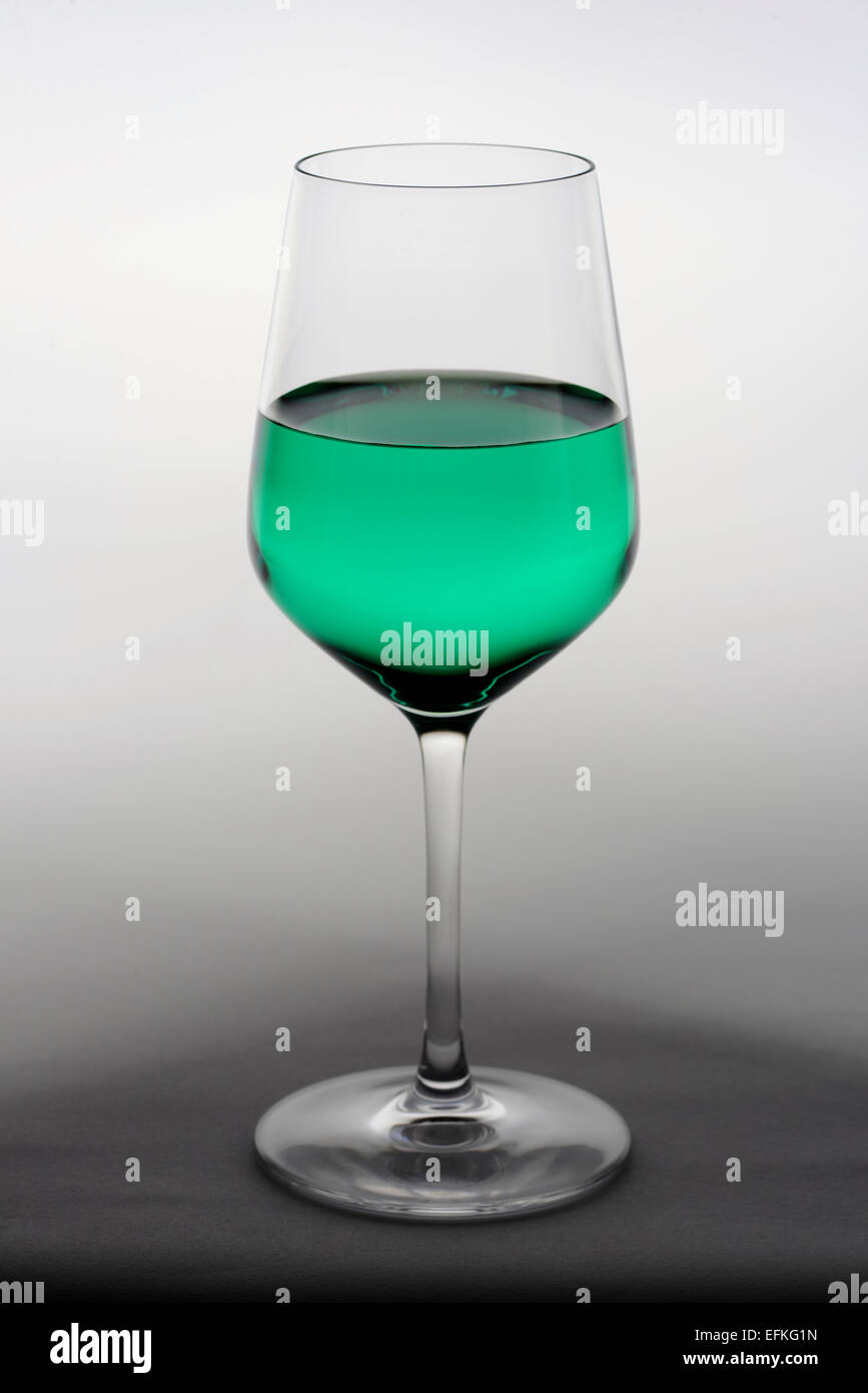 Wine glass with green colored liquid Stock Photo