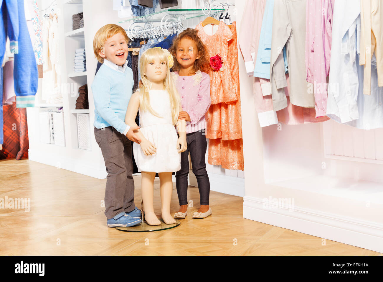 Boy and laughing girl stand with doll mannequin Stock Photo Alamy