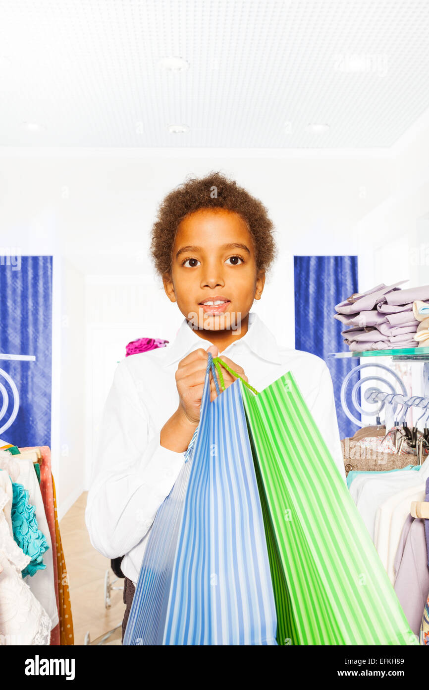 African boy wears white shirt with bags in store Stock Photo