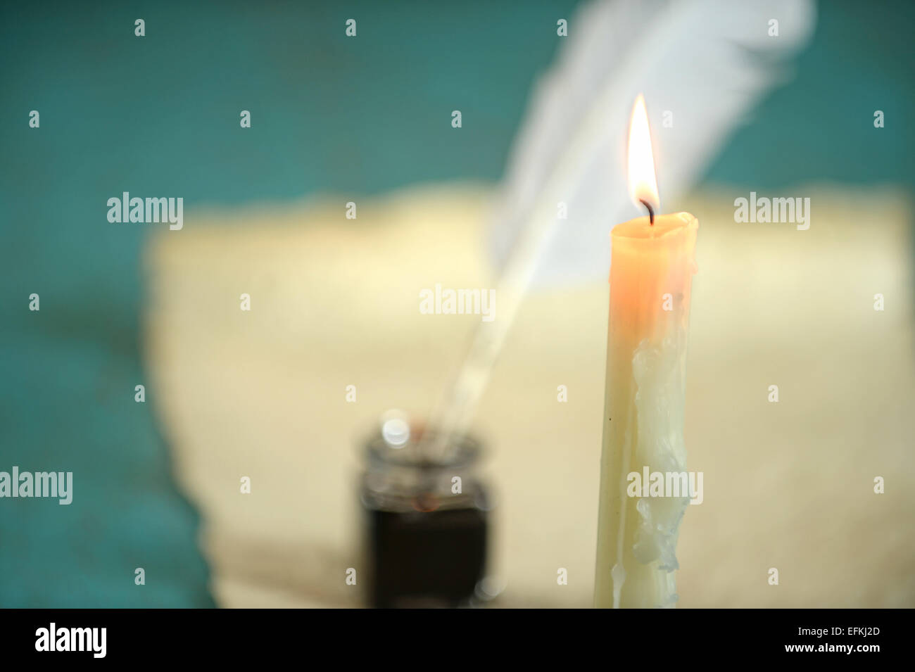 Candle burning with paper and inkwell in background Stock Photo Alamy