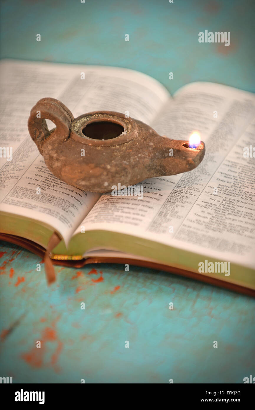 Vintage oil lamp over open Bible on old table Stock Photo Alamy