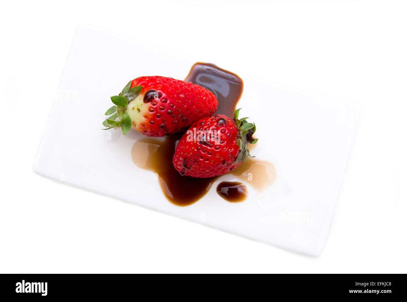Strawberries with balsamic vinegar on a white background seen from