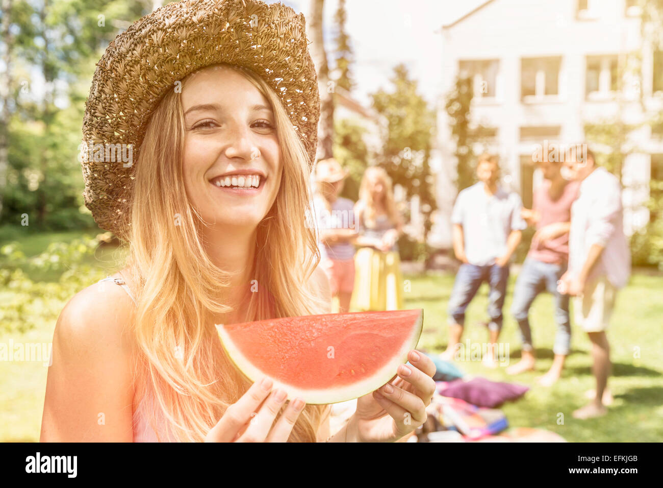 Woman wearing straw hat eating watermelon Stock Photo Alamy