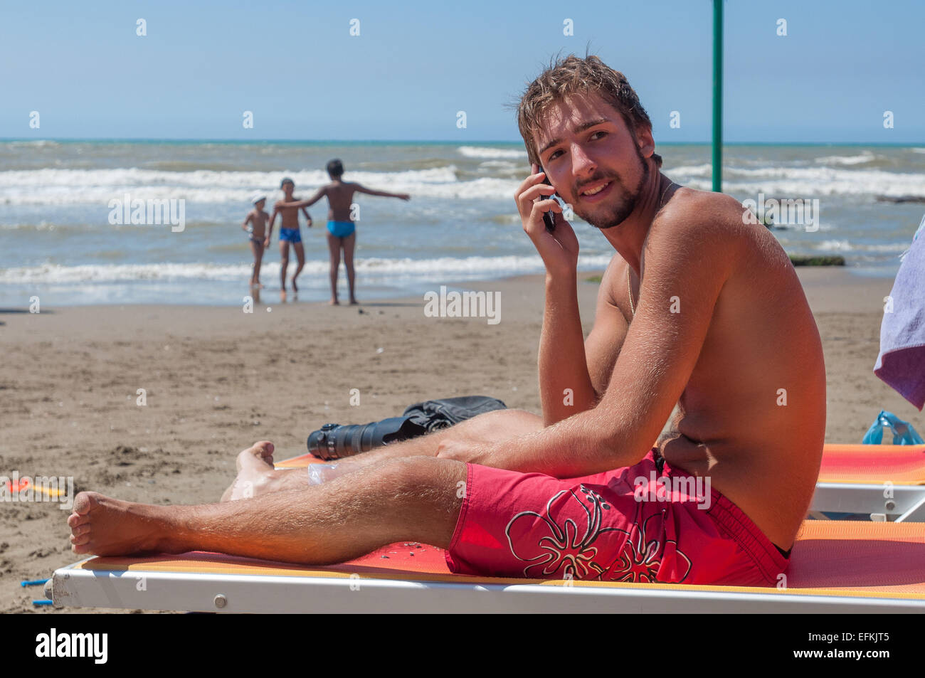 A boy talking at the cell phone on the beach Stock Photo
