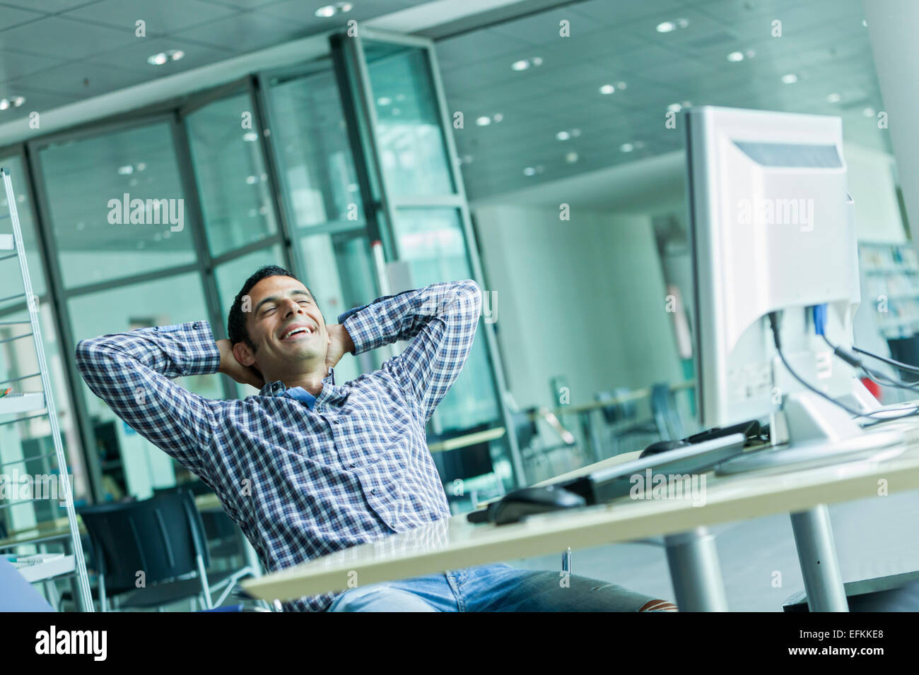 Man leaning back in chair laughing Stock Photo Alamy
