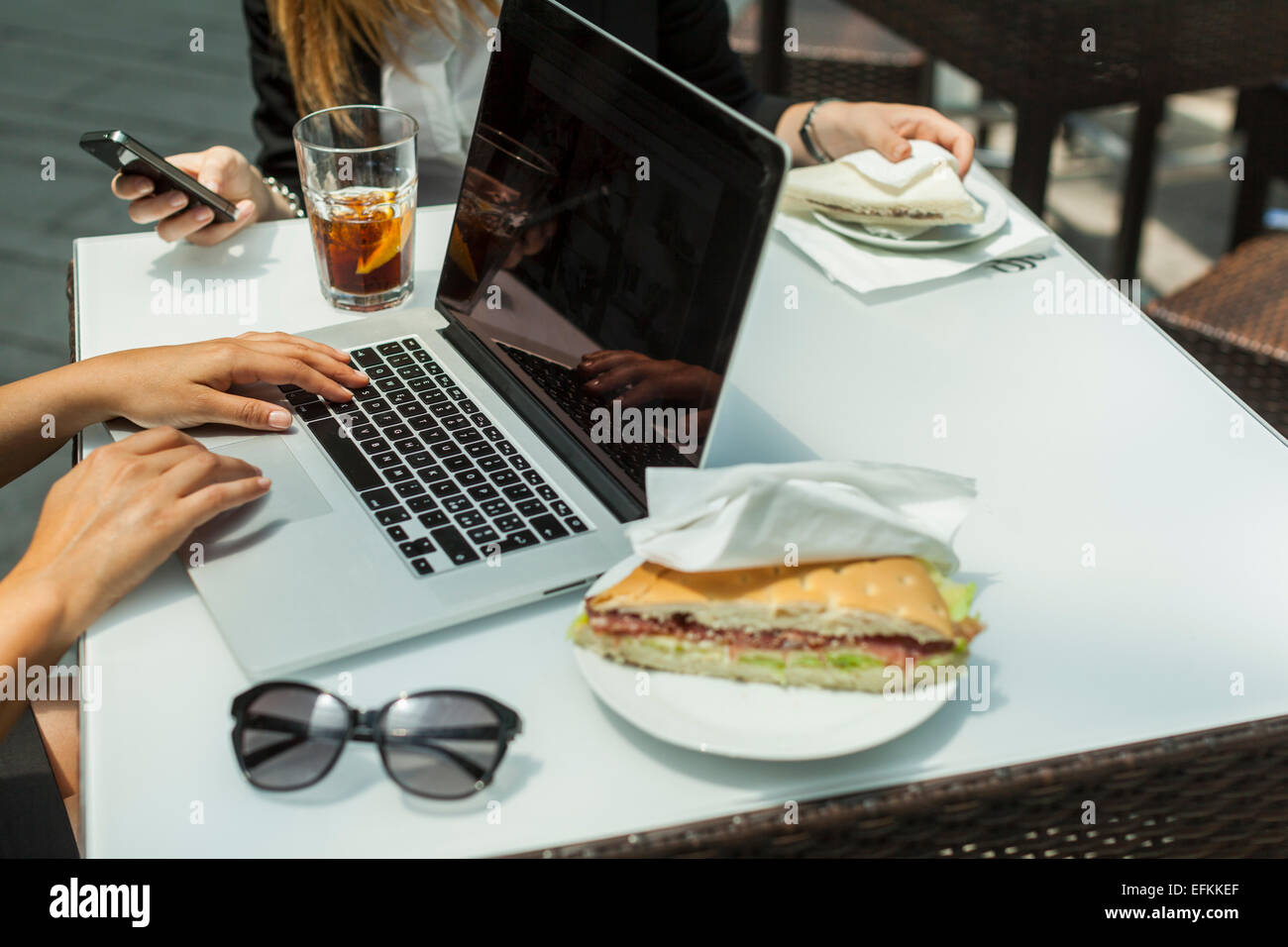 Businesswomen using laptop on working lunch Stock Photo Alamy