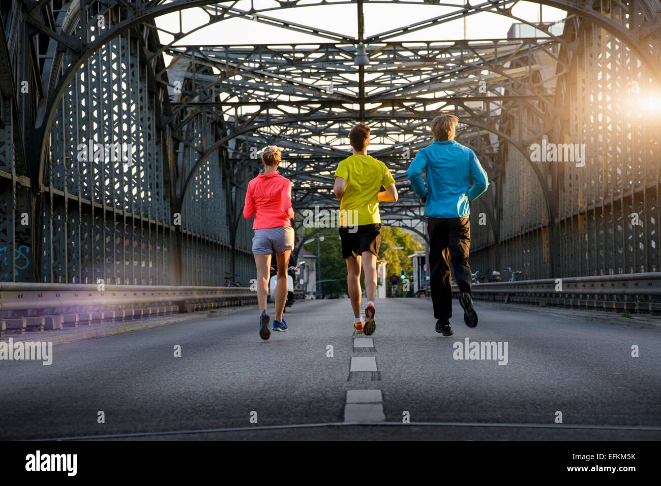 Friends jogging on bridge, Munich, Bavaria, Germany Stock Photo