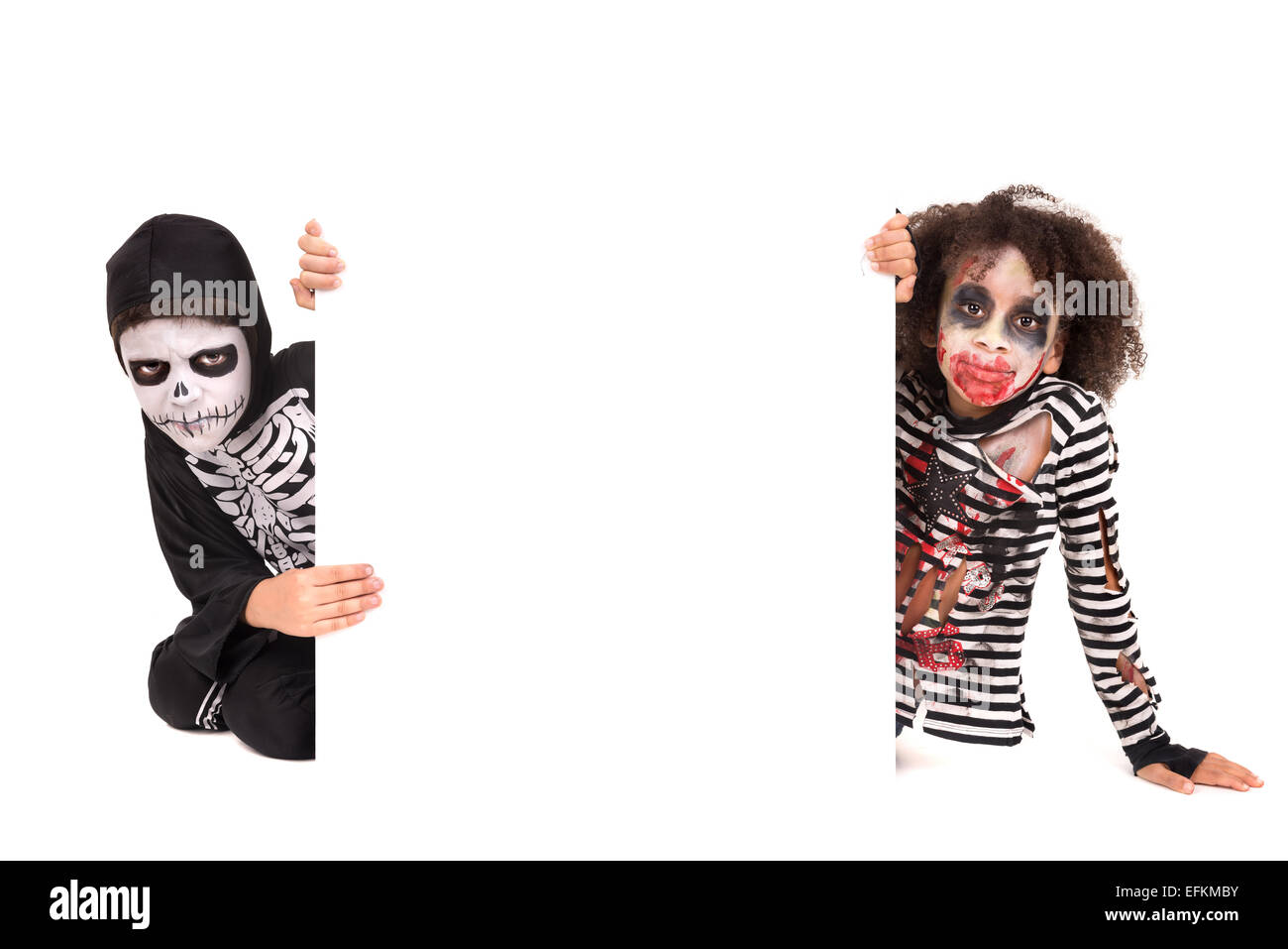 Kids with face-paint and Halloween costumes over a white board Stock Photo