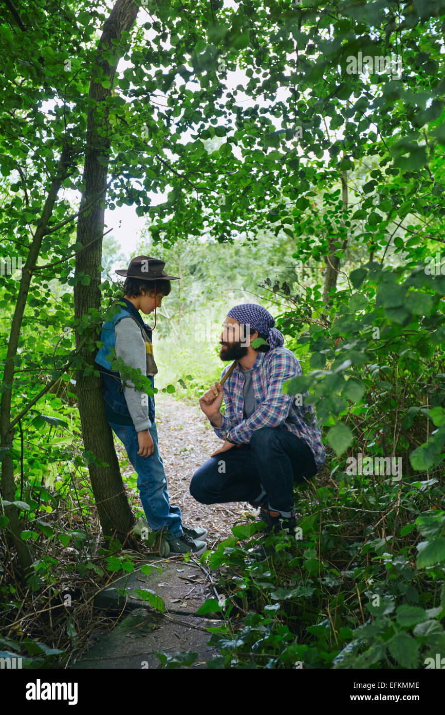 Father advising son in forest Stock Photo