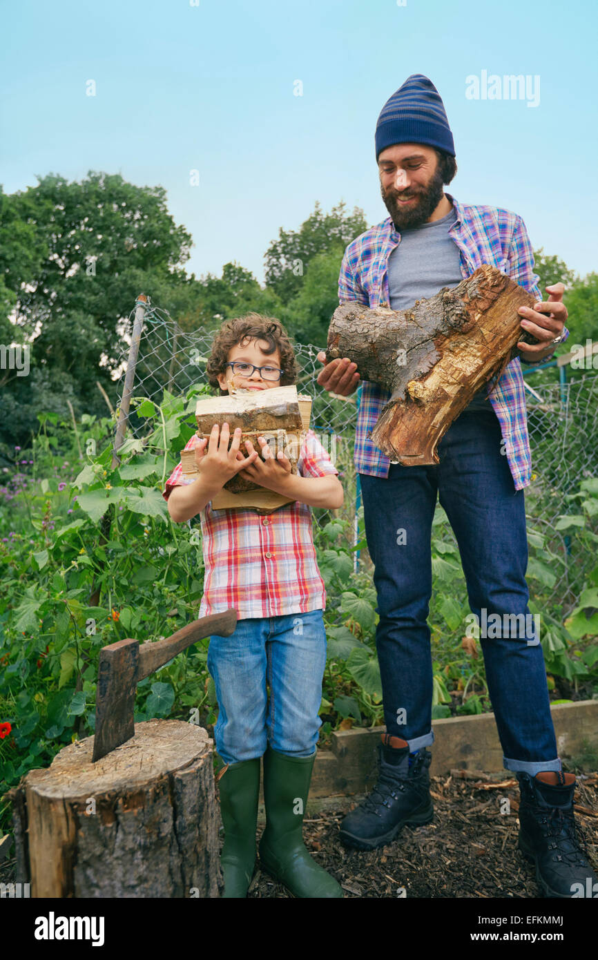 Father and son with chop logs on allotment Stock Photo