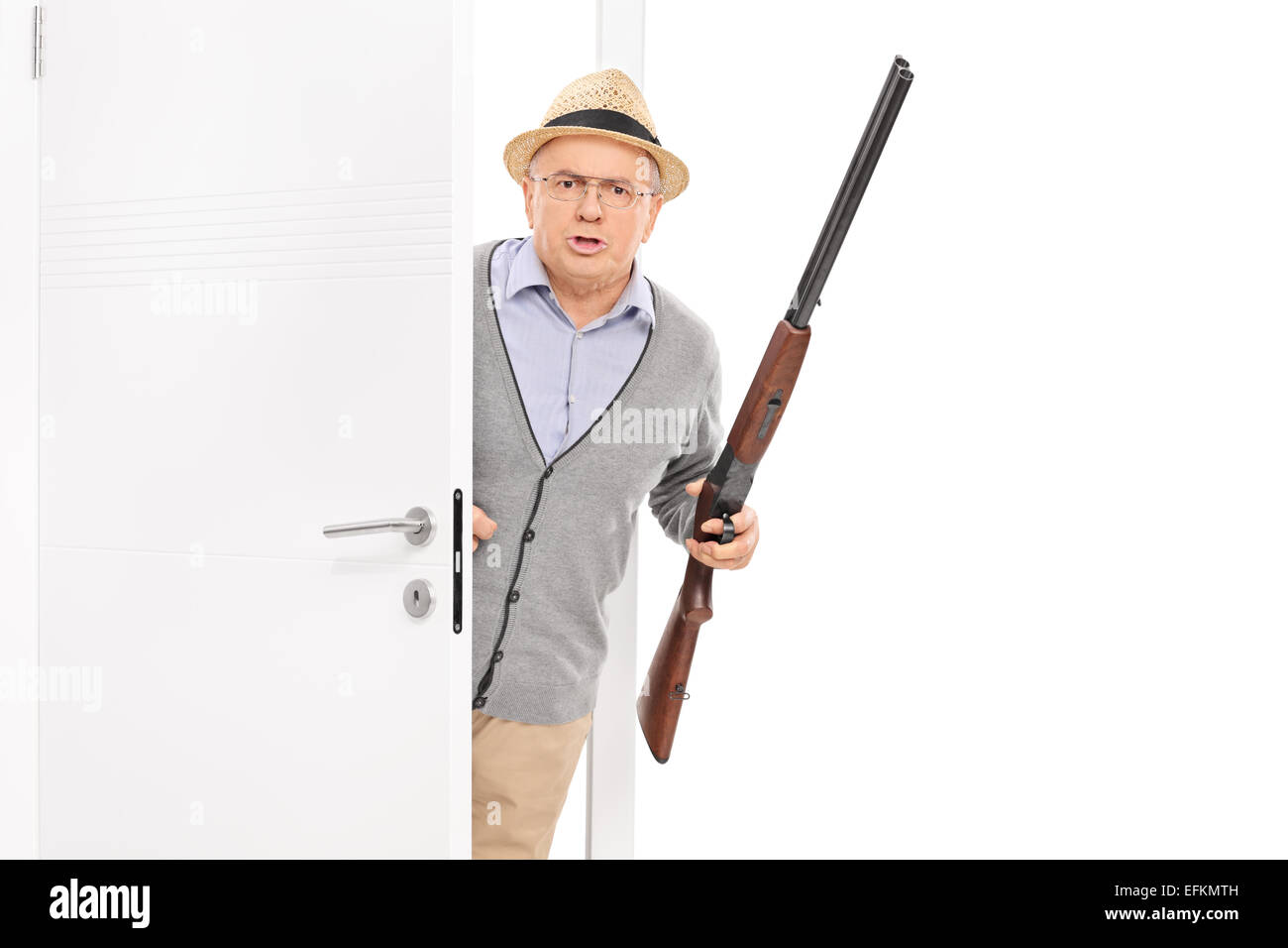 Senior with rifle bursting through a door isolated on white background Stock Photo