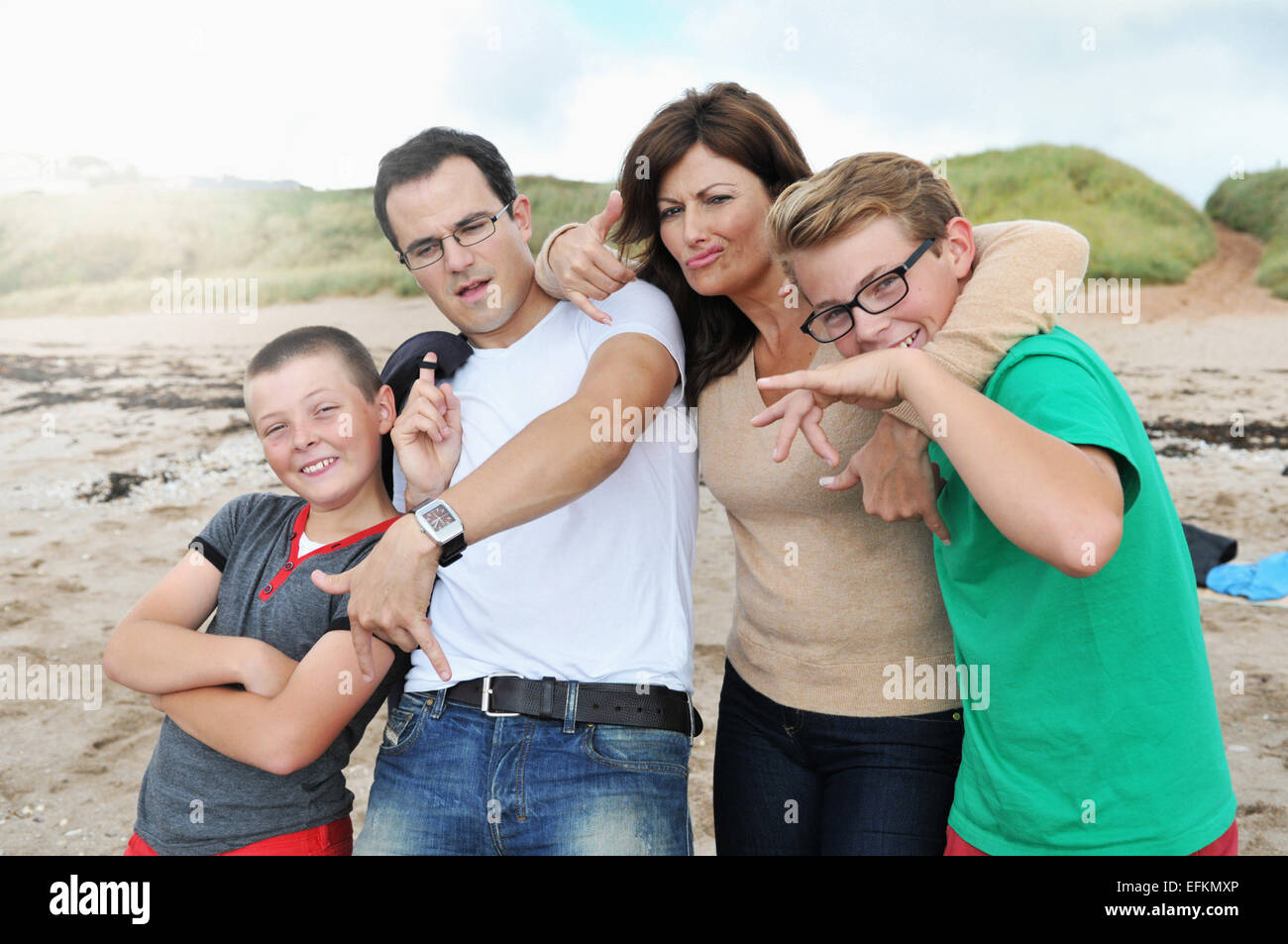 Portrait of parents and two sons fooling around on beach, Thurlstone, Devon, UK Stock Photo