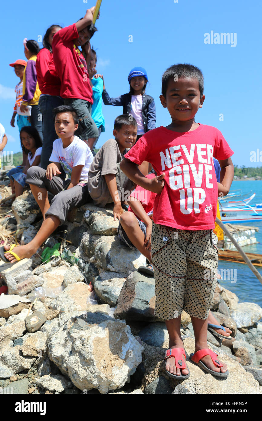 Boy with shirt saying NEVER GIVE UP on the by Typhoon Haiyan/Yolanda devastated fishing island Naborot, Iloilo, The Philippines Stock Photo