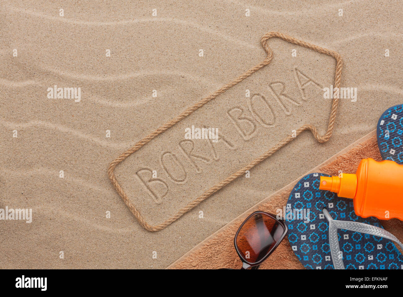 Bora Bora  pointer and beach accessories lying on the sand, as background Stock Photo
