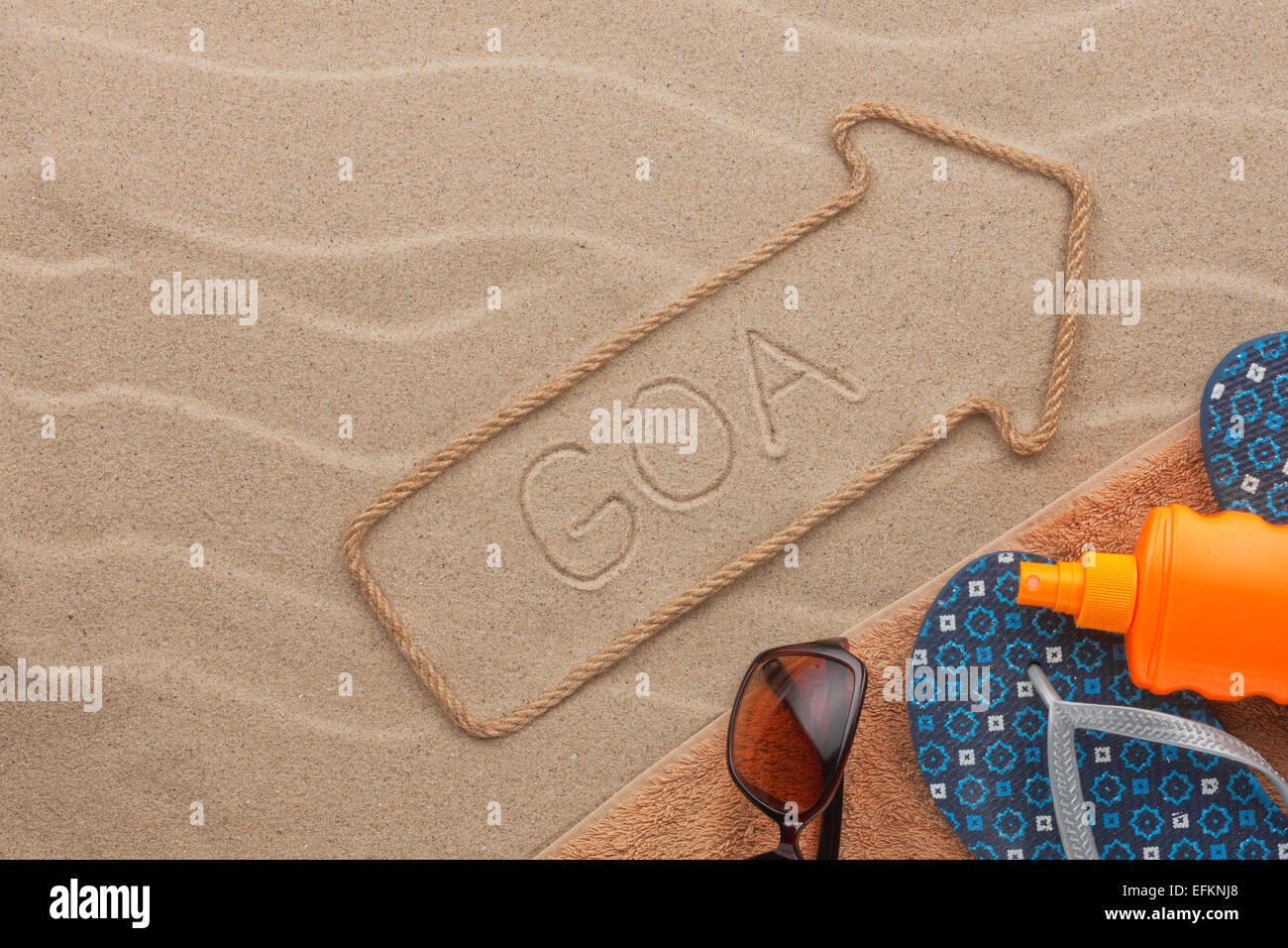 Goa pointer and beach accessories lying on the sand, as background Stock Photo