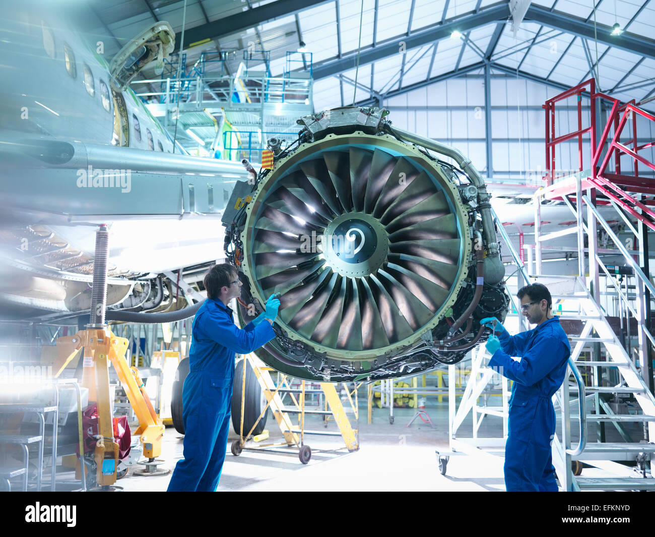 Aircraft engineers working on jet engine in aircraft maintenance factory Stock Photo