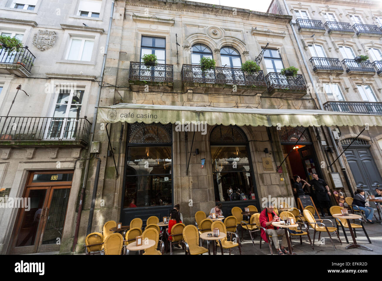 People gathered outside a cafe casino in a historic European street setting