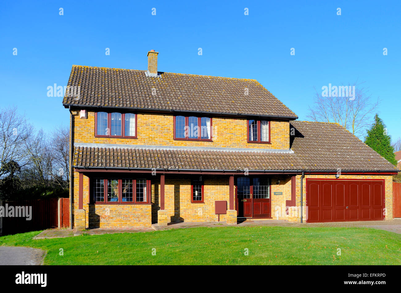 Large 4 5 bedroom executive style detached house exterior garage front lawn & drive against a blue sky Kent England UK Stock Photo