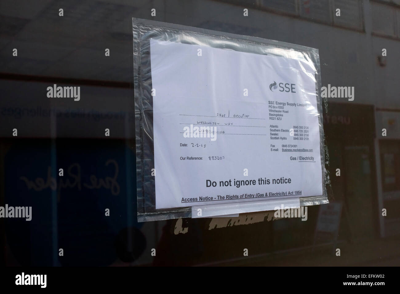 Access notice taped to the front of an empty shop to read an electricity meter Stock Photo