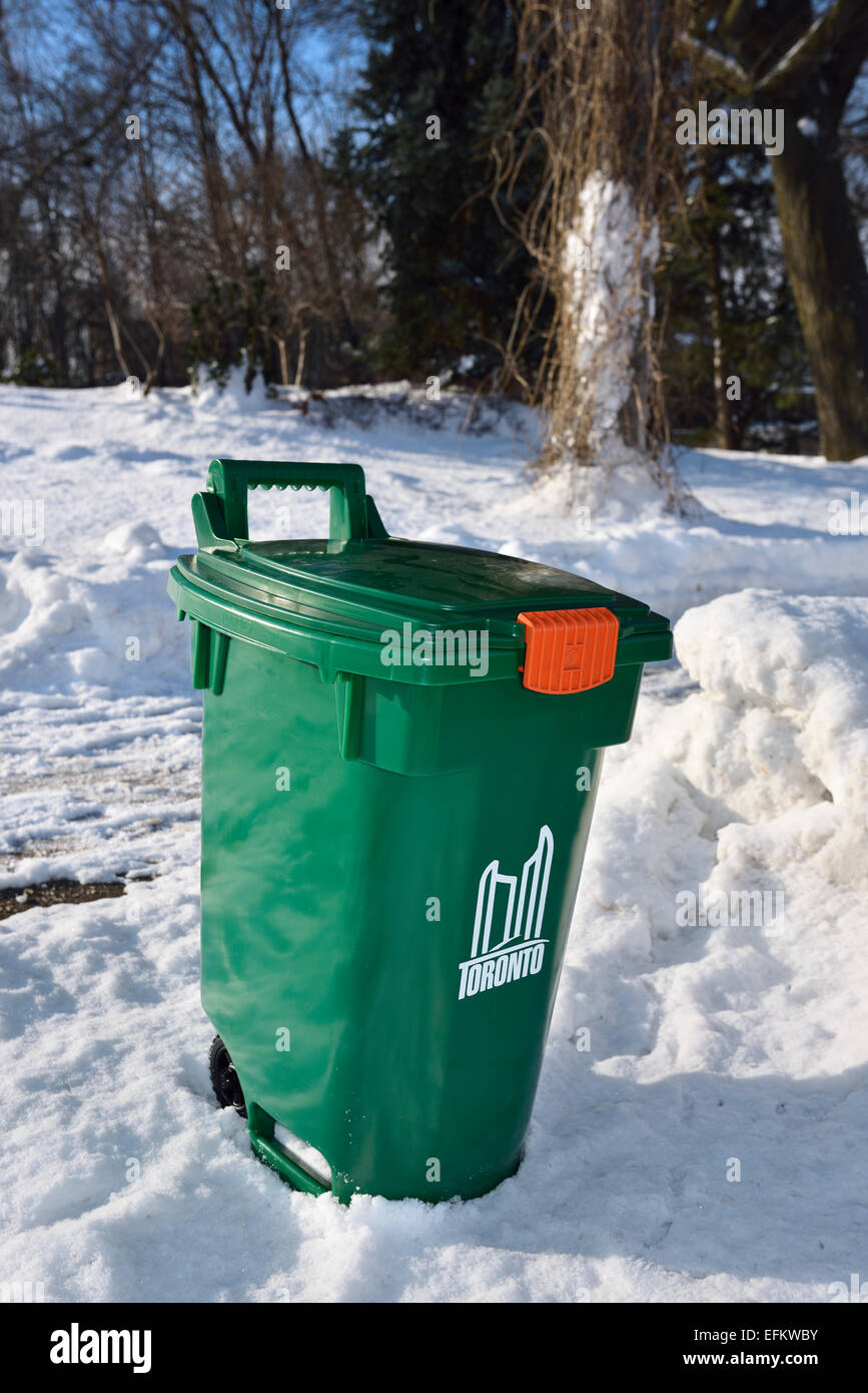 Metropolitan Toronto green bin beside snowbank in winter waiting for street pickup Stock Photo