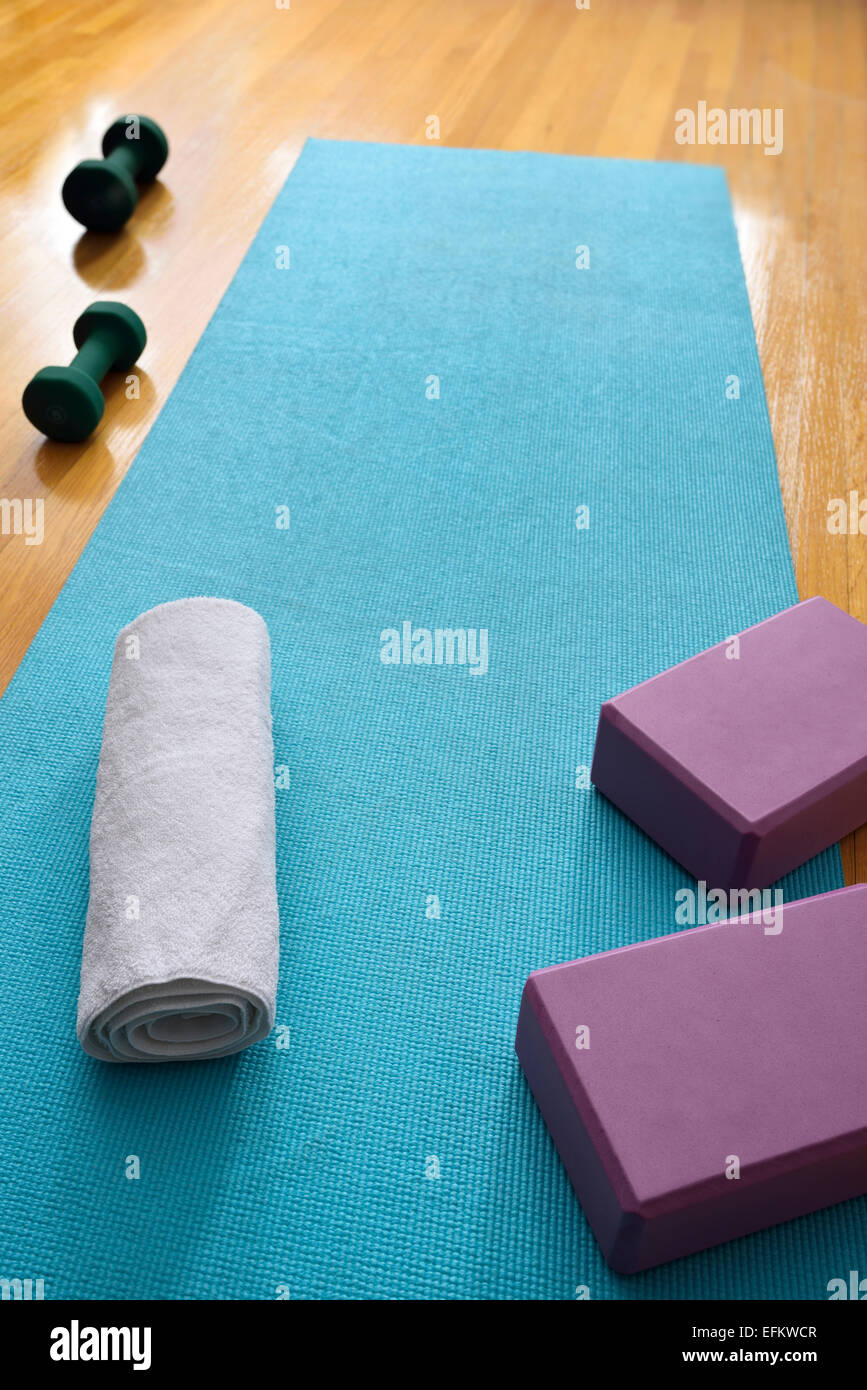 Blue yoga mat in gym exercise studio with fresh towel and blocks and