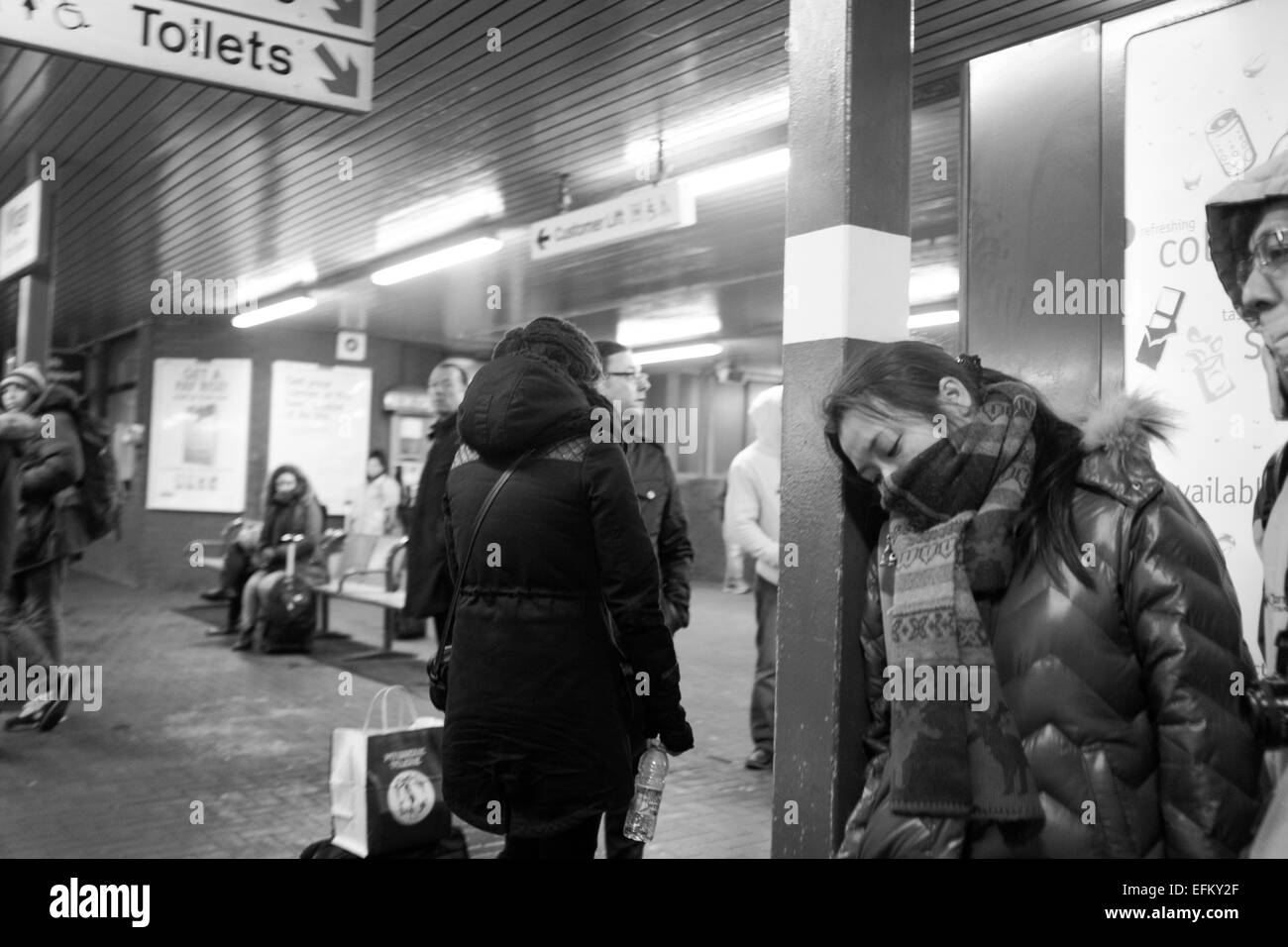 Girl sleeping while standing and waiting for a train Stock Photo