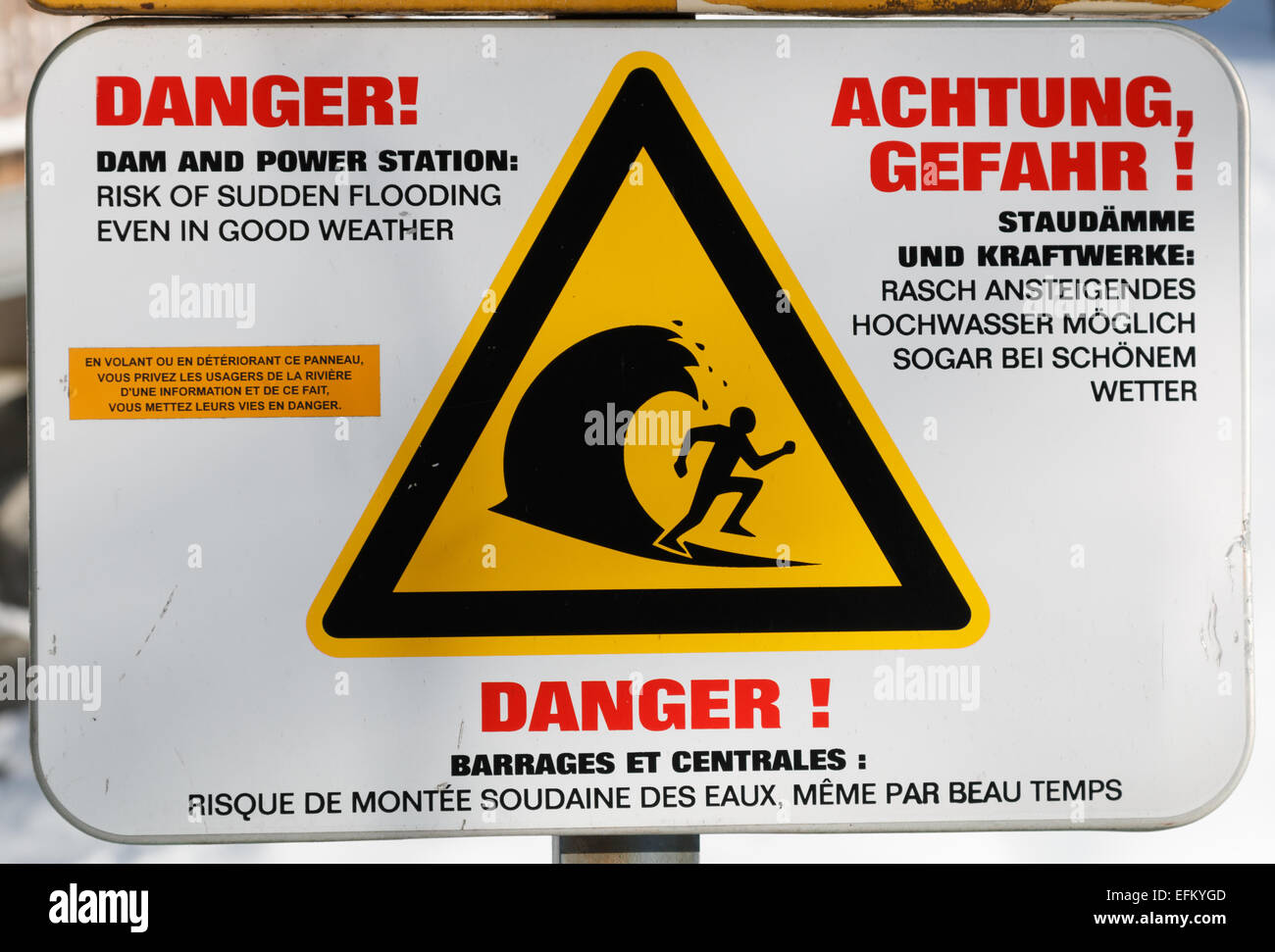 Danger sign showing that there is a risk of sudden flood in hydroelectric powers system rivers. Stock Photo