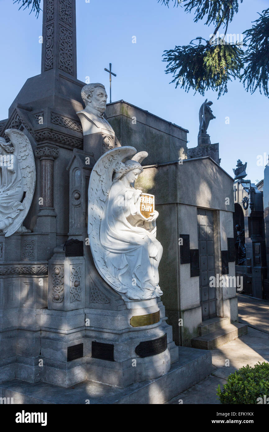 White marble angel statue on a tomb at Recoleta Cemetery, Buenos Aires, Argentina holding a shield inscribed 'Father Fahy' Stock Photo