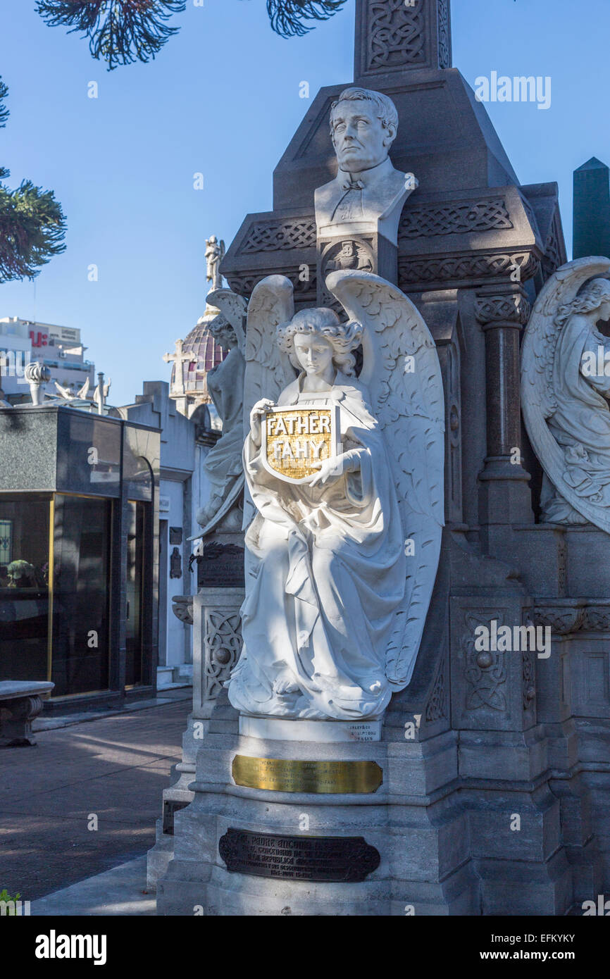 White marble angel statue on a tomb at Recoleta Cemetery, Buenos Aires, Argentina holding a shield inscribed 'Father Fahy' Stock Photo