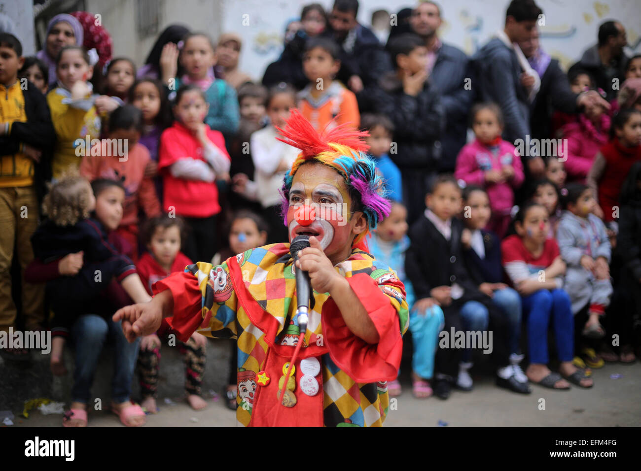 Gaza City, Gaza Strip. 6th Feb, 2015. A clown performs in front of Palestinian children during a street game organised by volunteers of the Friday of Joy Initiative, in al-Shati refugee camp. © Khaled Al-Sabbah/APA Images/ZUMA Wire/Alamy Live News Stock Photo