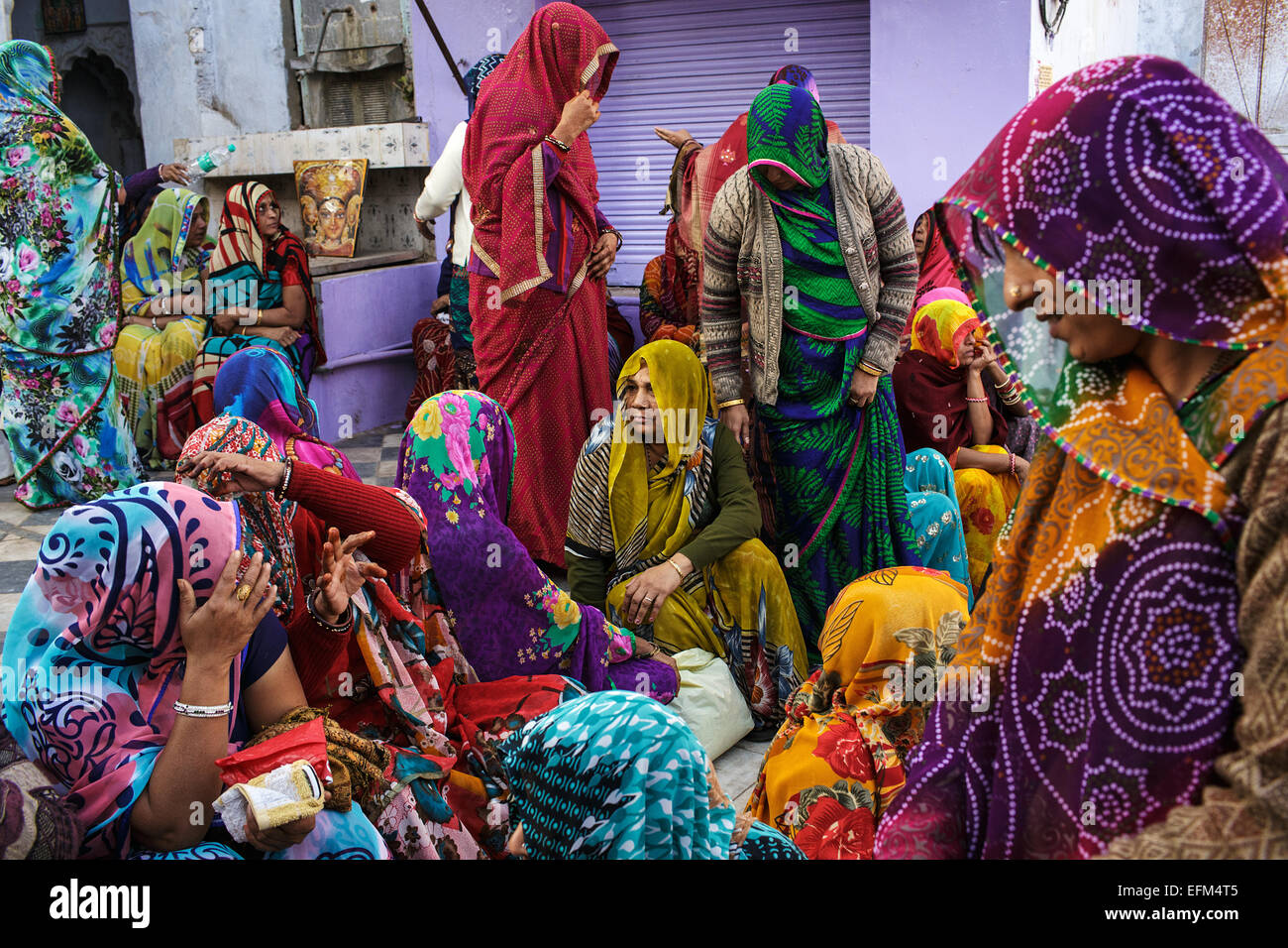 A group of colorfully dressed women mourning a death of a person in Pushkar, Rajasthan, India Stock Photo