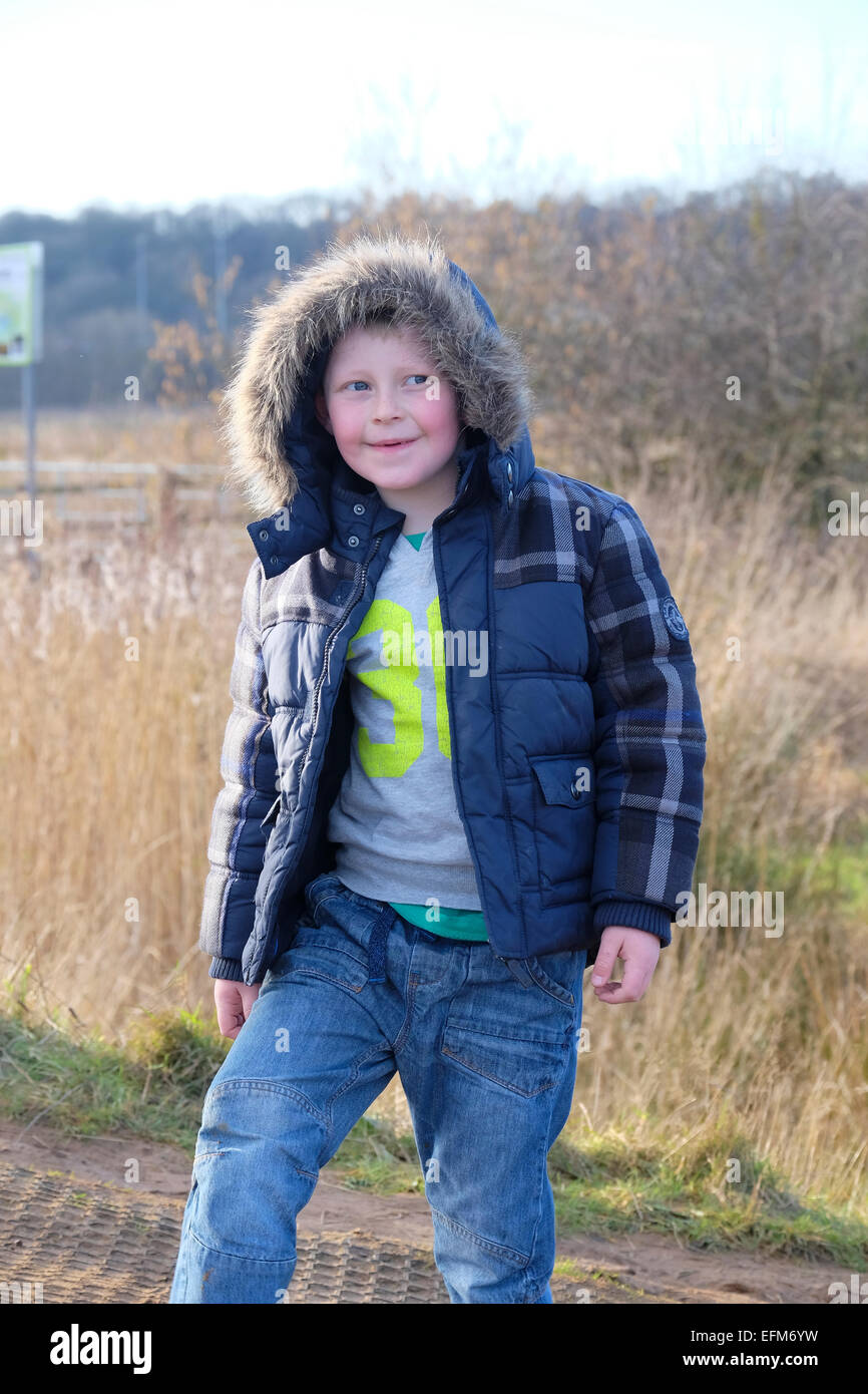 Boy in winter coat outdoors in countryside Stock Photo